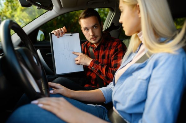 Woman and man with checklist, driving school