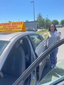 Happy student holding a passed road test paper