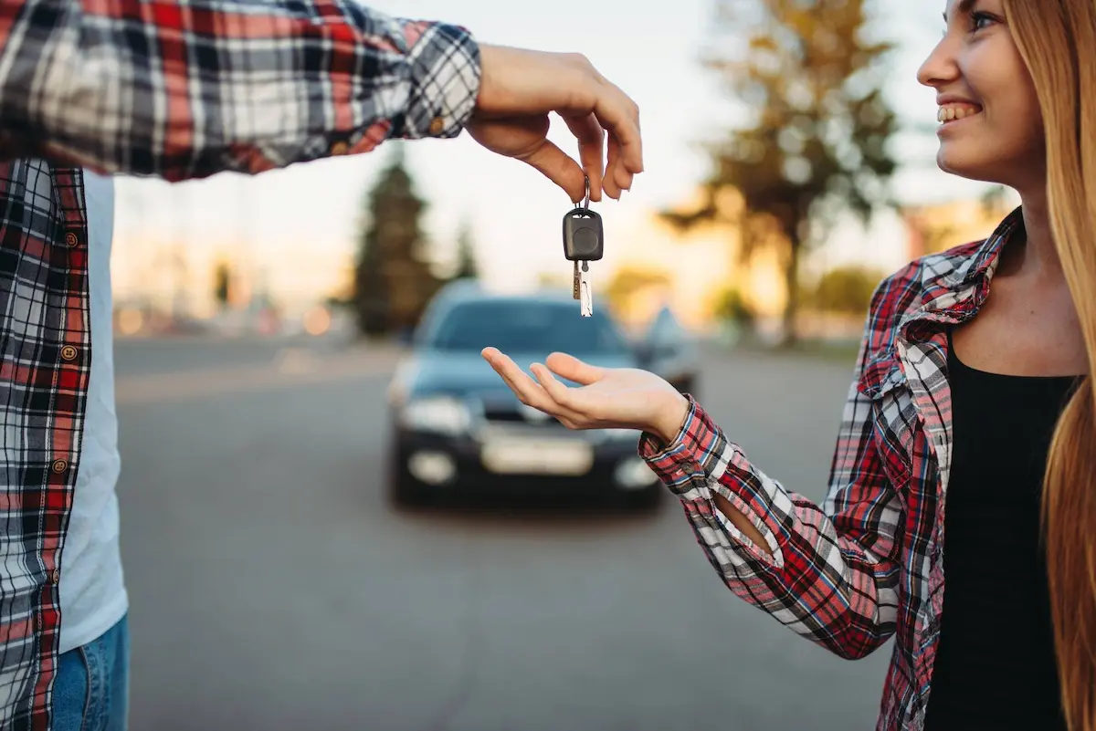 Instructor handing car keys to student after road test