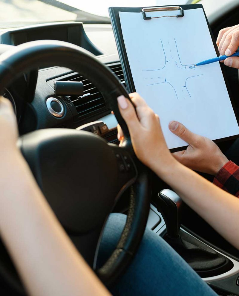 woman-and-man-with-checklist-driving-school-78XWWYU.jpg